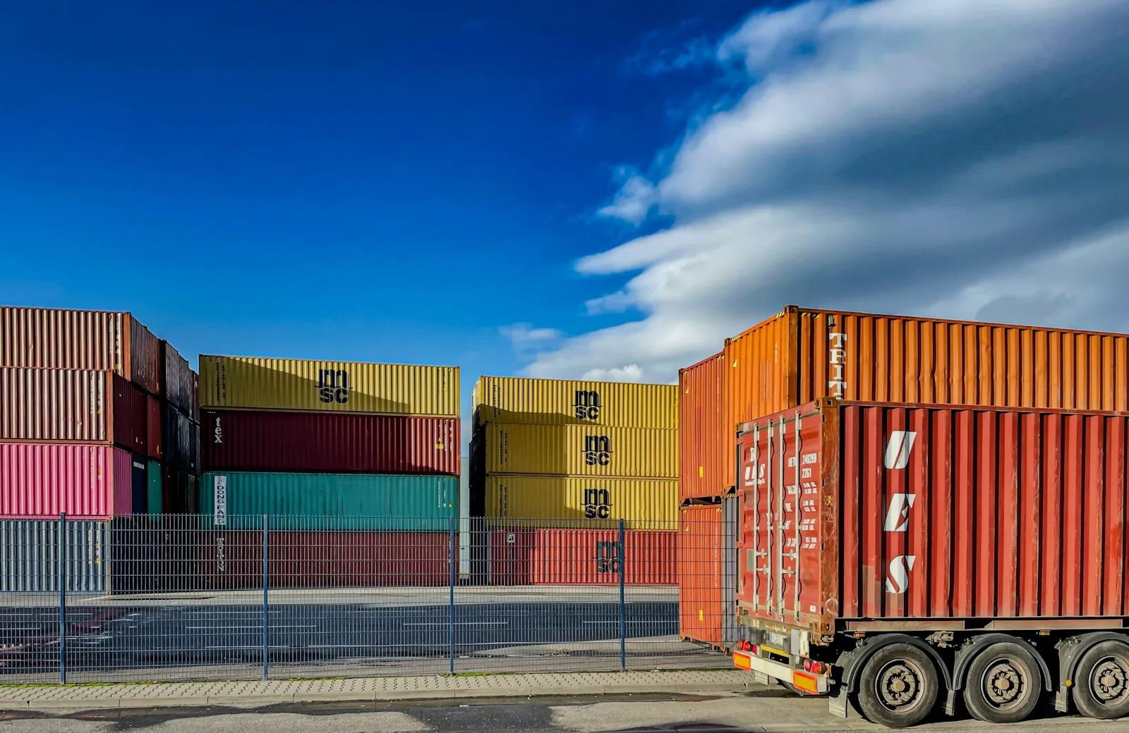 Truck beside stacked containers at a terminal